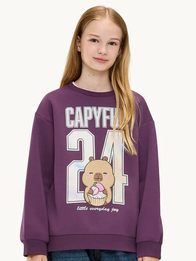 Teen girl wearing a CapyFun capybara varsity sweatshirt