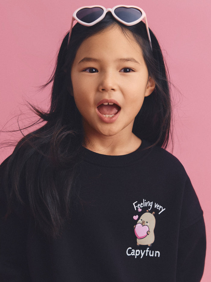 Girl wearing a CapyFun capybara sweatshirt, licensed kids apparel