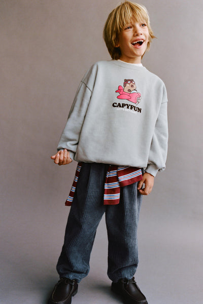 Boy wearing a grey CapyFun capybara sweatshirt