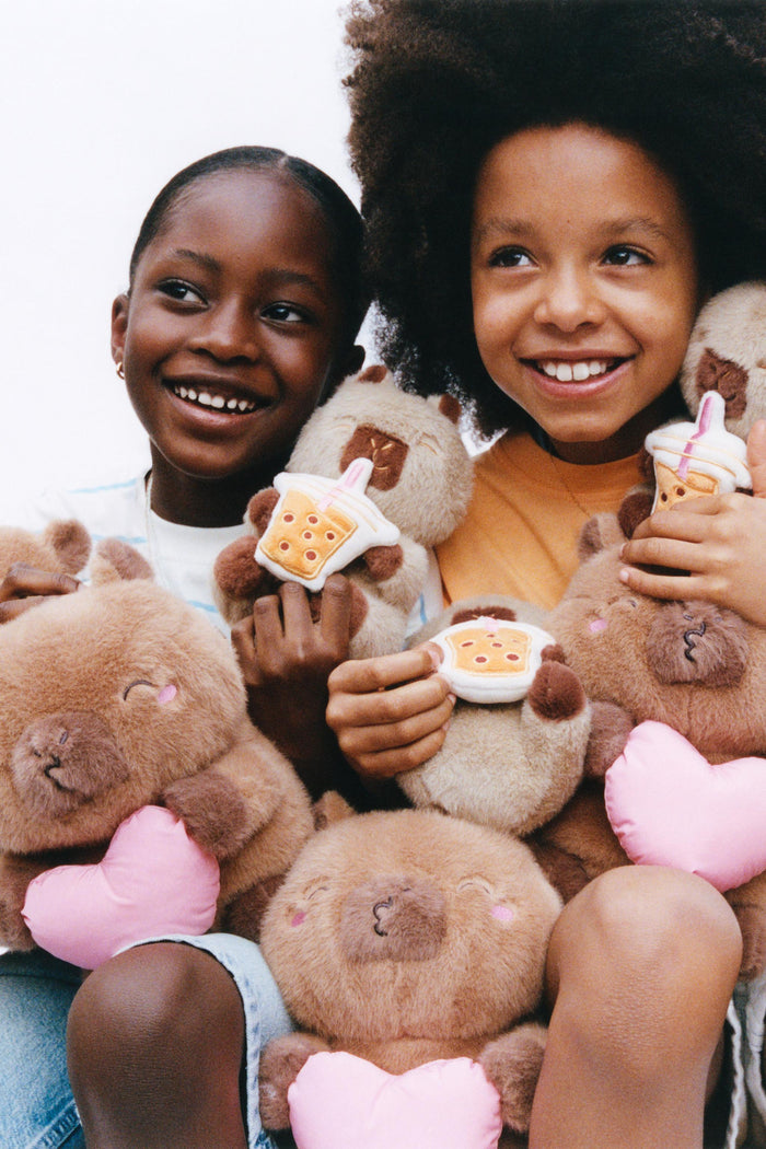 Kids hugging CapyFun capybara plush toys